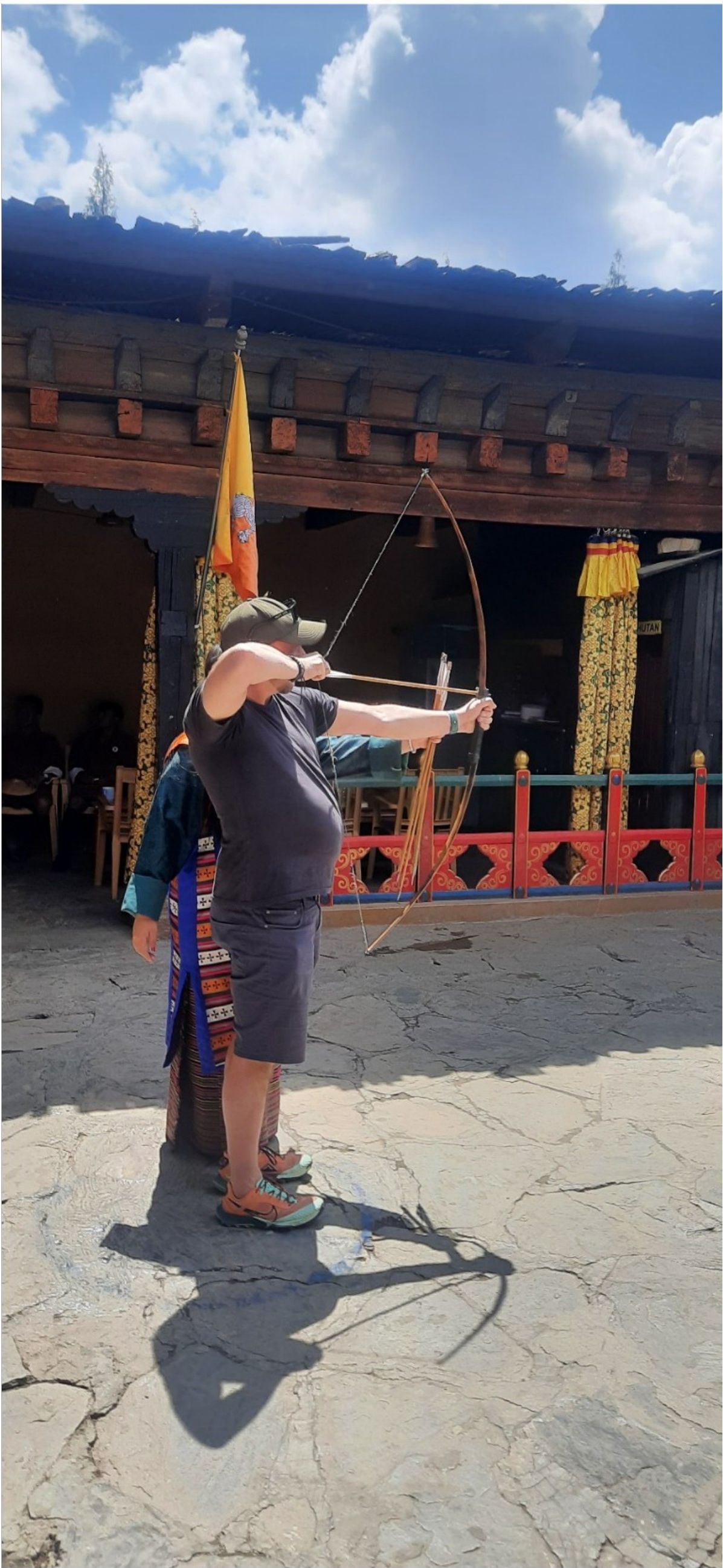 Traveler trying traditional Bhutanese archery